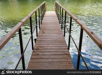 wooden gangway with railings on the lake