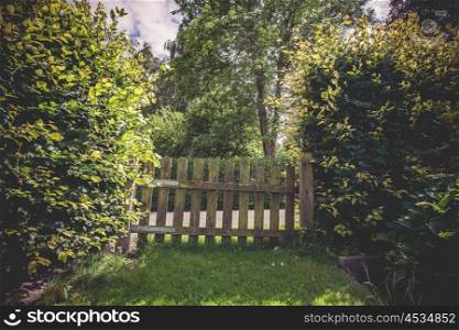 Wooden gate in a green garden in the summer