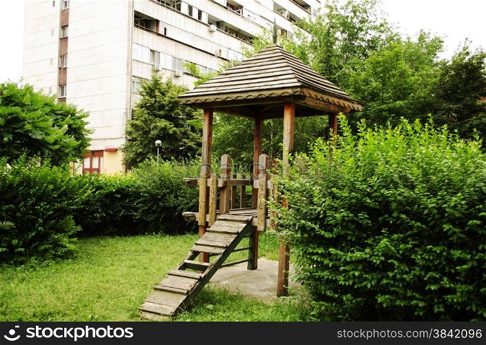Wooden gazebo in a shady playground area of the park