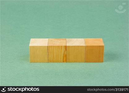wooden geometric cube on a green background