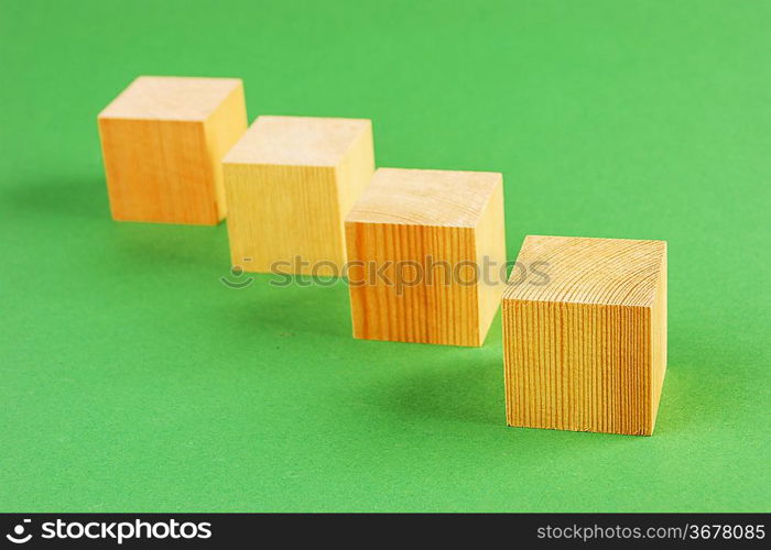 wooden geometric cube on a green background