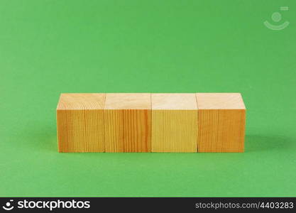 wooden geometric cube on a green background