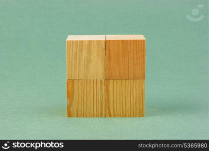 wooden geometric cube on a green background