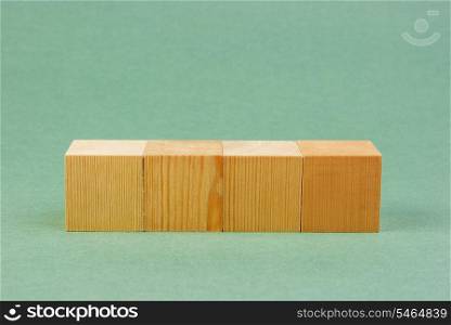 wooden geometric cube on a green background