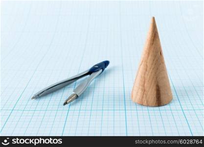 Wooden geometric shape cone on graph paper