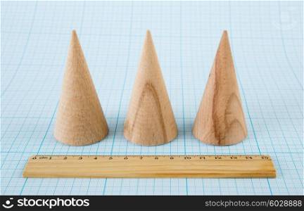 Wooden geometric shape cone on graph paper