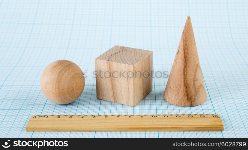 Wooden geometric shapes on graph paper