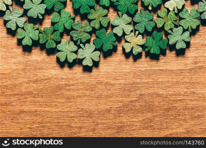 Wooden green shamrocks laying on the wooden floor. St. Patrick?s Day. Symbol of luck.. Wooden green shamrocks laying on the wooden floor.