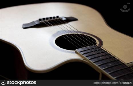 Wooden guitar with lighting on the body to show texture of guitar