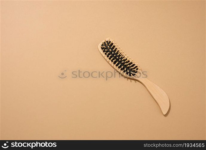 wooden hair comb on brown background, zero waste. Top view