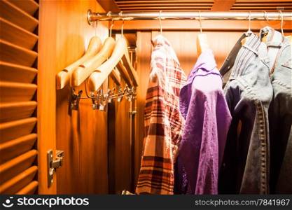 Wooden hanger in wood wardrobe with clothes