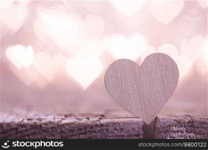 Wooden heart on beautiful pink bokeh background. Vintage style. Love Valentine’s Day concept.. Hearts on bokeh background