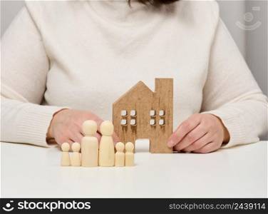 wooden house and figures of a family. Real estate insurance concept, happy family