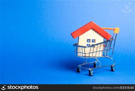 Wooden house in a Supermarket trading cart. The concept of buying a house or apartment. Affordable housing. Profitable and cheap loans for real estate. Buying a home. Mortgage and loan. Place for text