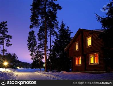 wooden house in winter wood in twilight