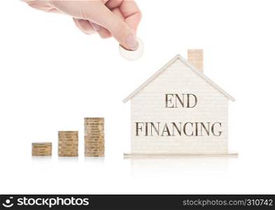 Wooden house model with coins next to it and hand holding the coin with conceptual text. End Financing