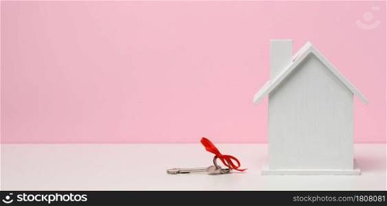 wooden house on a pink background. Real estate rental, purchase and sale concept. Realtor services, building repair and maintenance, copy space