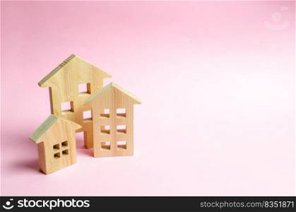 Wooden houses on a pink background. The concept of the city or town. Investing in real estate, buying a house. Management and business management, market coverage. Construction of buildings.