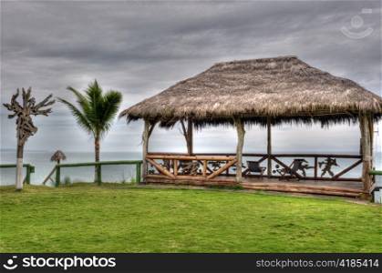wooden hut with a roof of palm leaves on a beach in Ecuador