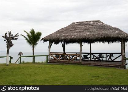 wooden hut with a roof of palm leaves on a beach in Ecuador