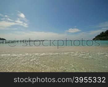 wooden jetty on sunny beach with nice sky background