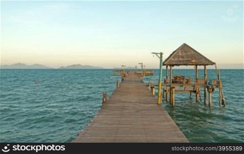 wooden jetty on sunny beach with nice sky background