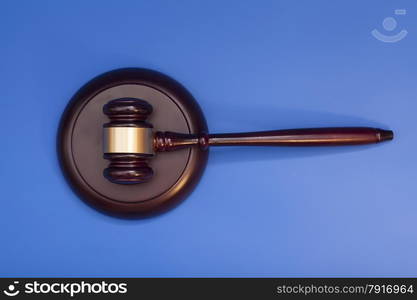 Wooden judge gavel and soundboard isolated on blue background