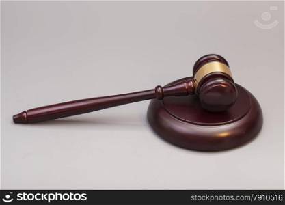 wooden judge gavel and soundboard on grey background