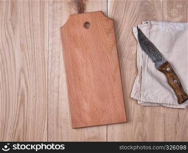wooden kitchen cutting board and a gray towel on a table, view from the top