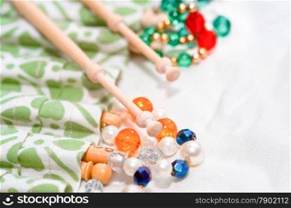wooden lacemaking bobbins and decorative beads on white linen
