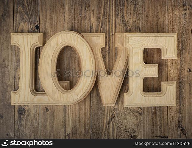 wooden letters forming the word love on a walnut wood background. Concept of St. Valentine&rsquo;s Day