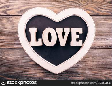 Wooden letters LOVE on heart shape chalkboard