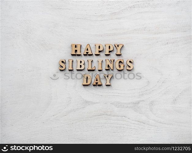 Wooden letters of the alphabet in the form of the words SIBLING DAY on the table. Beautiful card. Isolated background, wooden surface. Congratulations for relatives, friends and colleagues. Happy SIBLING DAY. Beautiful card.