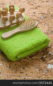 wooden massager and hairbrush on towel