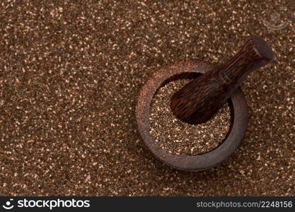 Wooden mortar full of organic natural chia seeds and pestel close-up. High quality photo. Wooden mortar full of organic natural chia seeds and pestel close-up