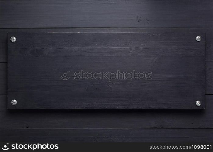 wooden nameplate at black background as texture surface with screws