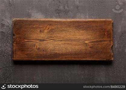 Wooden nameplate or sign board screwed on wall background. Front view of name plate