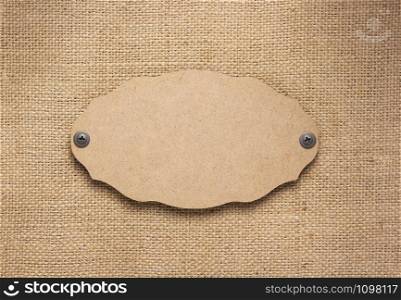 wooden nameplate or wall sign at burlap hessian sacking texture surface as background texture