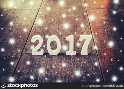 Wooden numbers forming the number 2017, For the new year and snow on a rustic wooden background.