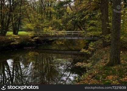 wooden old bridge in the nature area of singraven in holland near the singraven castle in Dinkelland, Netherlands. wooden bridge in autumn forest in nature area singraven