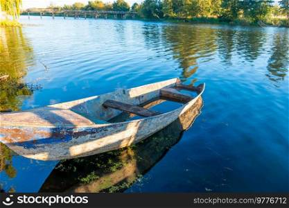 Wooden old fishing boat on river at sunset