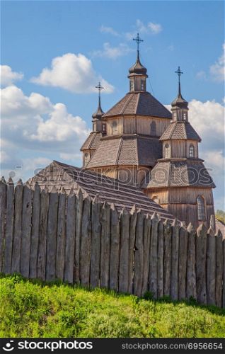 wooden old house with wooden fence on green grass. Ukraine Zaporizhia Sich. wooden house