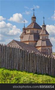 wooden old house with wooden fence on green grass. Ukraine Zaporizhia Sich. wooden house