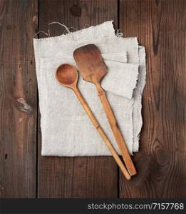 wooden old spoon and spatula on a gray linen napkin, top view