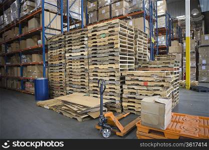 Wooden pallets stacked in distribution warehouse