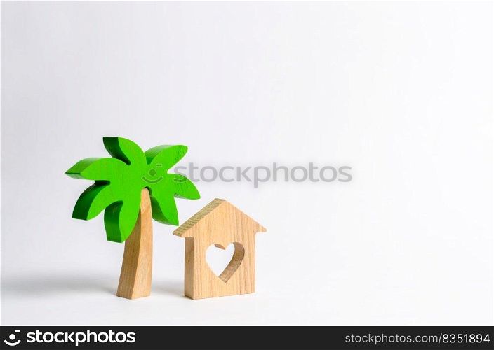 Wooden palm tree and house with hearts on a white background. Conceptual leisure and vacation. Rental homes and properties in the resort. Romantic travel. Entertainment and relaxation.