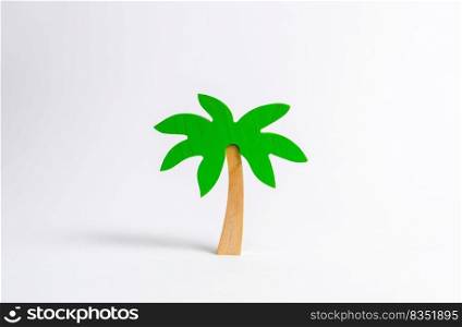 Wooden palm tree on a white background. Tours and cruises to warm countries. The development of tourism. Tropical island. Conceptual leisure and vacation, entertainment and relaxation.