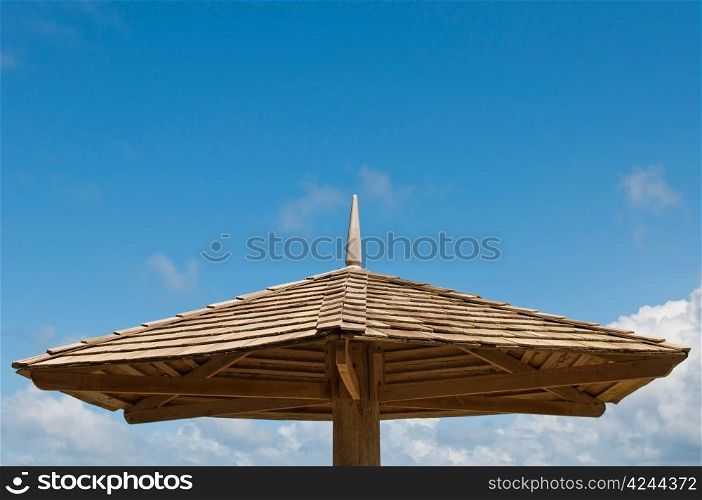 wooden parasol against a blue sky background (copy-space available)
