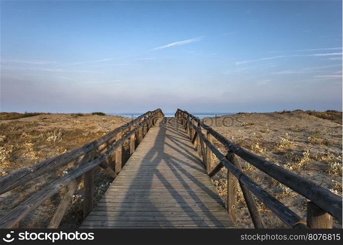 Wooden path to the beach. Morning sky