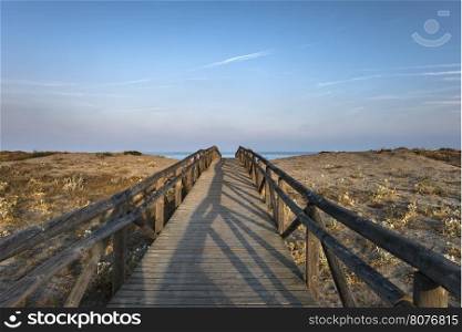 Wooden path to the beach. Morning sky